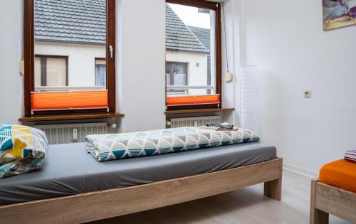 a bed in a room with two windows at 3 Zimmer Wohnung für max. 5 Personen in Alzey