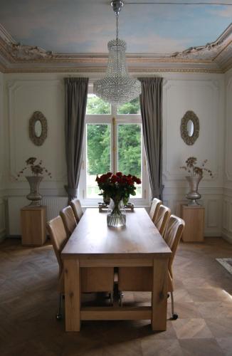 une salle à manger avec une table et un vase de fleurs dans l'établissement Chateau Sourliavoux, appartement en chambres d'hôtes, à Vallières