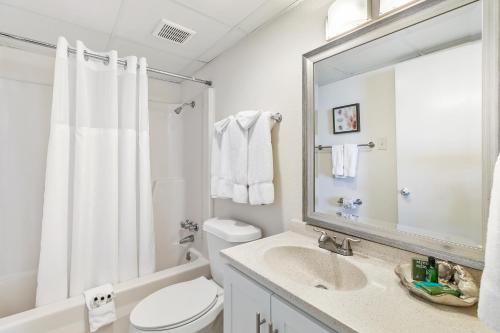 uma casa de banho com um WC, um lavatório e um espelho. em Recently renovated! 3 beachfront balconies Beautiful and fully equipped condo em South Padre Island