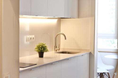 a kitchen with white cabinets and a sink at Espinach Port Serrallo in Tarragona