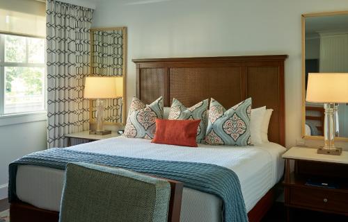 a bedroom with a bed with pillows and two lamps at Inn By the Sea in Cape Elizabeth