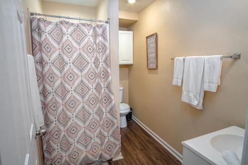y baño con ducha, aseo y toallas. en Houston St Guest house near Downtown/Military base, en San Antonio