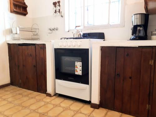 a kitchen with a stove and wooden cabinets at Casa frente al Mar Aguas Verdes in Aguas Verdes