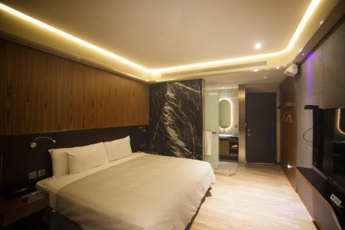 a bedroom with a large white bed in a room at LE LE Motel in Pingtung City