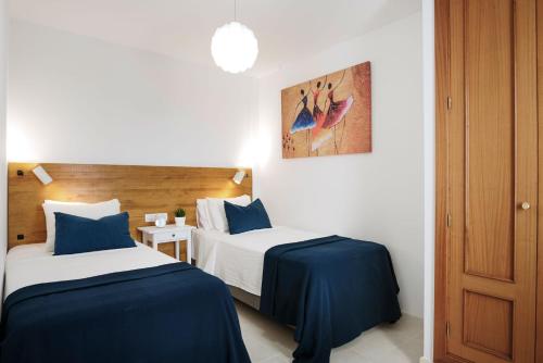 Cette chambre d'hôtel comprend 2 lits avec des draps bleus. dans l'établissement Villa Clara, à Playa Blanca