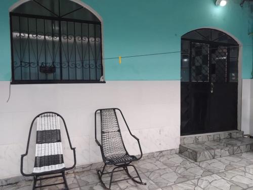 two chairs sitting next to a wall with a door at Casa De férias in Manaus
