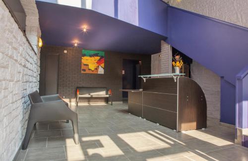 a room with a chair and a purple ceiling at Hotel Restaurant Vesontio in Besançon