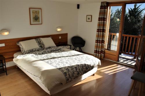a bedroom with a bed and a balcony at Chambres d'hôtes Les Peschiers in Chateauroux-les-Alpes