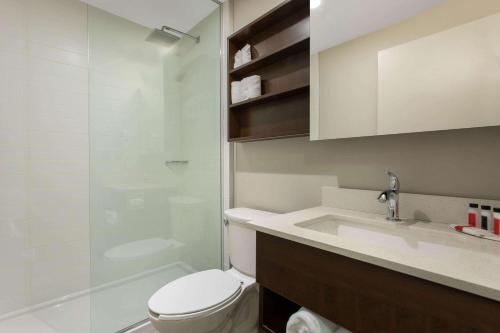 a bathroom with a toilet and a sink and a shower at Microtel Inn & Suites by Wyndham Mont Tremblant in Mont-Tremblant