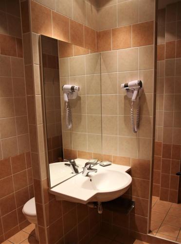 une salle de bain avec un lavabo et des toilettes dans l'établissement Chambres d'hôtes Les Peschiers, à Châteauroux-les-Alpes