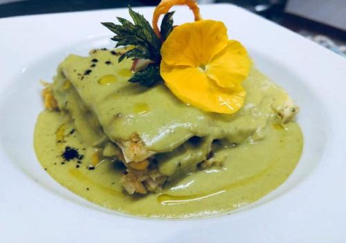 a white plate with a piece of food with yellow sauce at Hotel Las Puertas de Tepoztlan in Tepoztlán