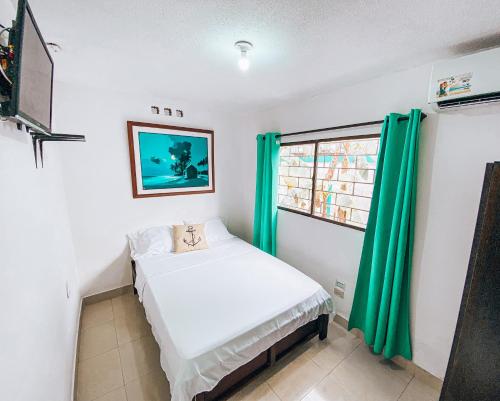 um pequeno quarto com uma cama e uma janela em Miss Julyn Sweet Home em San Andrés