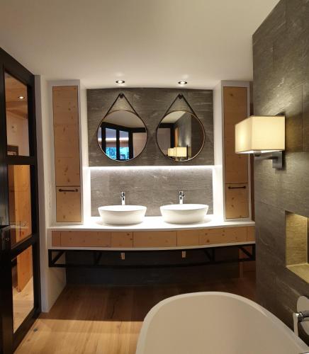 a bathroom with three sinks and a mirror at The Chalet Davos, Chesa Surlej in Davos