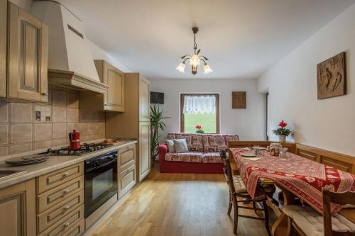 a kitchen and dining room with a table and a couch at Agritur Broch in Fiera di Primiero