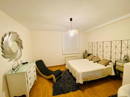 a bedroom with a bed and a dresser and a mirror at Chinchon Spa in Chinchón