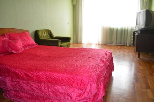 una camera con letto rosso e sedia di скд46 a Sumy