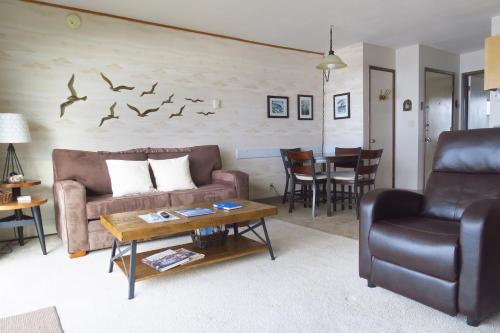 a living room with couches and a table with birds on the wall at Ocean Terrace Condominiums in Lincoln City