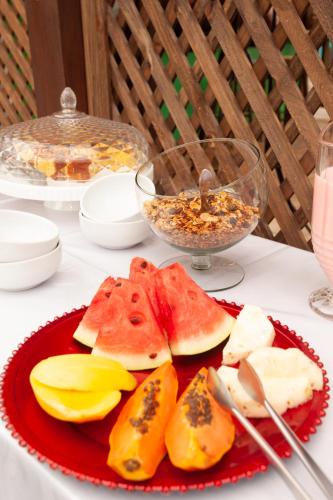 a red plate with slices of fruit on a table at Recanto do Sossego in Garopaba