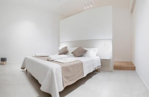 a white bedroom with a large bed with white walls at Cattolica Apartments in Cattolica