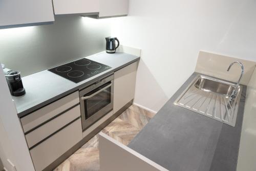 a white kitchen with a stove and a sink at Cattolica Apartments in Cattolica