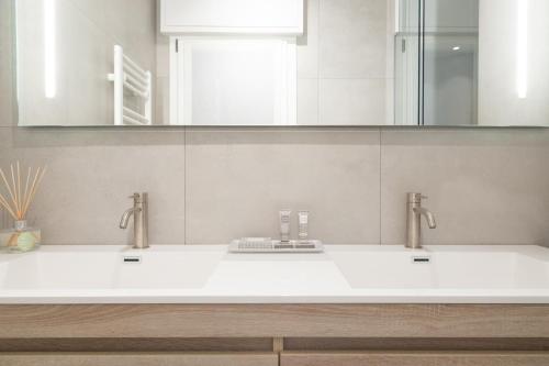 a bathroom with two sinks and a mirror at Cattolica Apartments in Cattolica