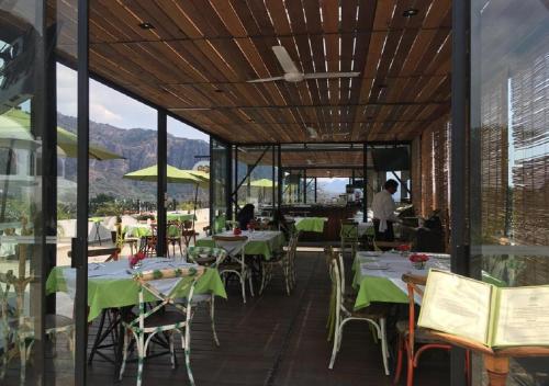 a restaurant with tables and chairs with mountains in the background at Hotel Las Puertas de Tepoztlan in Tepoztlán
