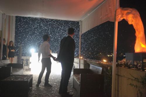 two people standing on a balcony at night at Villa Fenaroli Palace Hotel in Rezzato