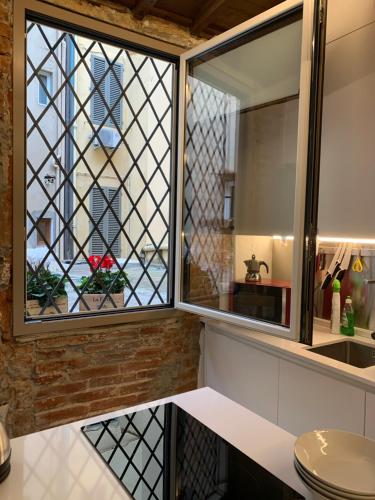 una cucina con finestra e lavandino di AI MAGAZZINI DEI MEDICI (casa con balcone) a Firenze