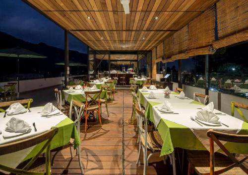 a restaurant with tables and chairs with green tablecloths at Hotel Las Puertas de Tepoztlan in Tepoztlán