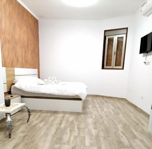 1 dormitorio con 1 cama y suelo de madera en Casa Brava, en Alicante