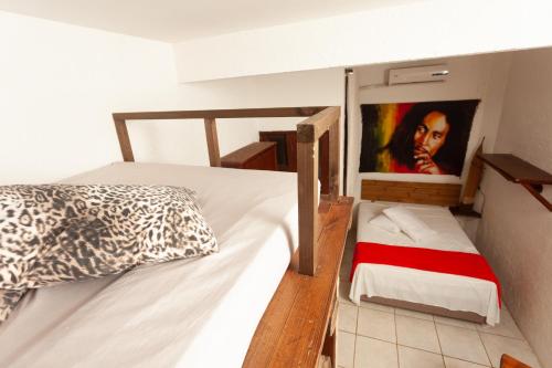 a bedroom with two beds and a painting on the wall at Recanto do Sossego in Garopaba