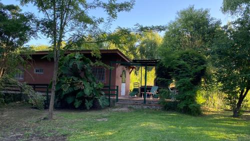 una casa roja con una valla y un patio en Marados y Marauno, en Tigre
