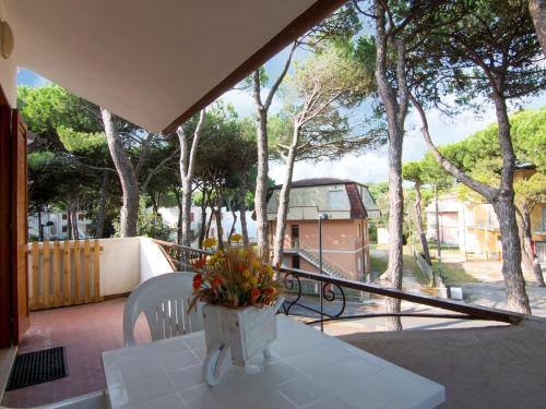 einen Tisch mit einer Blumenvase auf dem Balkon in der Unterkunft Belvilla by OYO Casa Pineta in Rosolina Mare