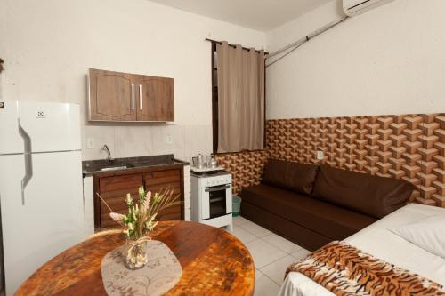 a small kitchen with a table and a couch at Recanto do Sossego in Garopaba