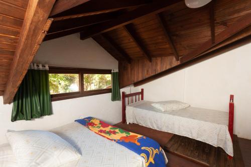 a bedroom with two beds and a window in it at Recanto do Sossego in Garopaba