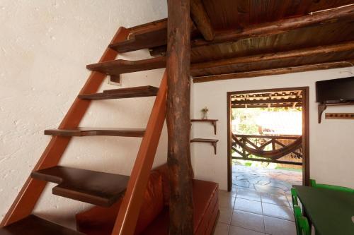 a wooden spiral staircase in a room with a door at Recanto do Sossego in Garopaba