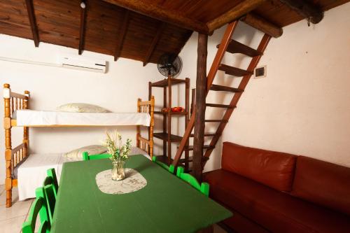 a room with a green table and bunk beds at Recanto do Sossego in Garopaba