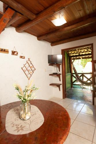 a room with a table with a vase of flowers on it at Recanto do Sossego in Garopaba