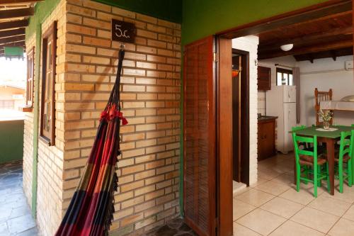 a broom hanging on the side of a brick wall at Recanto do Sossego in Garopaba