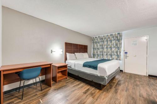 Habitación de hotel con cama, escritorio y silla en Motel 6-Tupelo, MS - Downtown en Tupelo
