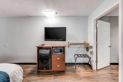 a room with a flat screen tv on a wall at Motel 6-Tupelo, MS - Downtown in Tupelo