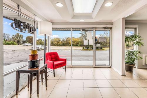 a living room with a red chair and a table at Motel 6-Tupelo, MS - Downtown in Tupelo