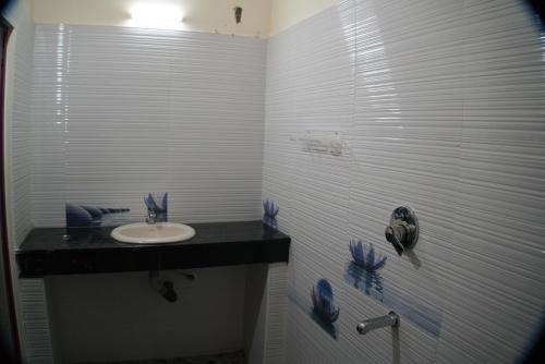 uma casa de banho com um lavatório e um chuveiro em Hotel Sunrise em Kanyakumari