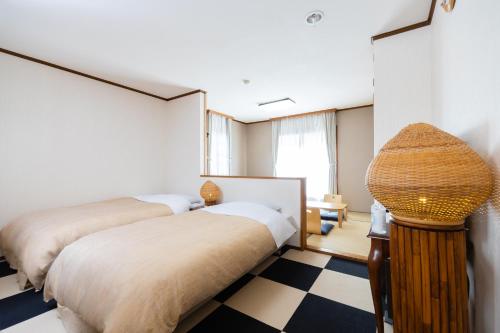 a bedroom with two beds and a checkered floor at Villa Rengatei in Hakuba