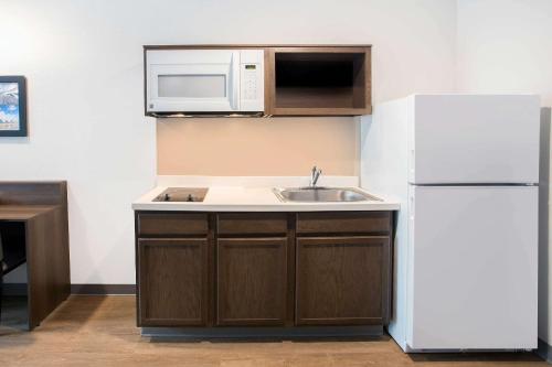 a kitchen with a sink and a white refrigerator at WoodSpring Suites Daytona Beach Int'l Speedway in Daytona Beach