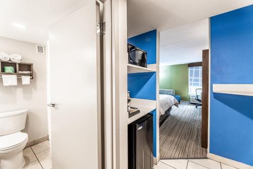 a bathroom with a toilet and a room with a bed at Holiday Inn Express Indianapolis South by IHG in Indianapolis