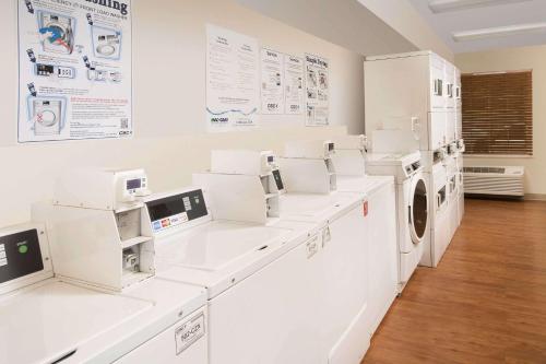 a laundry room with white washers and dryers at WoodSpring Suites Augusta Riverwatch in Augusta