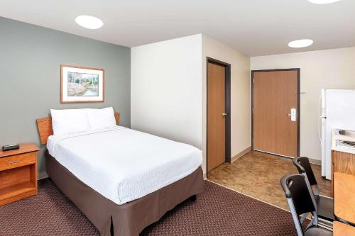 スーフォールズにあるWoodSpring Suites Sioux Fallsのベッドとキッチン付きのホテルルーム