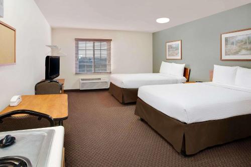 een hotelkamer met 2 bedden en een wastafel bij WoodSpring Suites Fort Wayne in Fort Wayne