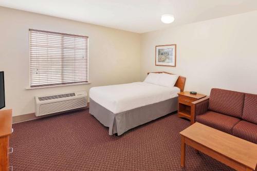 Un pat sau paturi într-o cameră la WoodSpring Suites Ankeny Des Moines